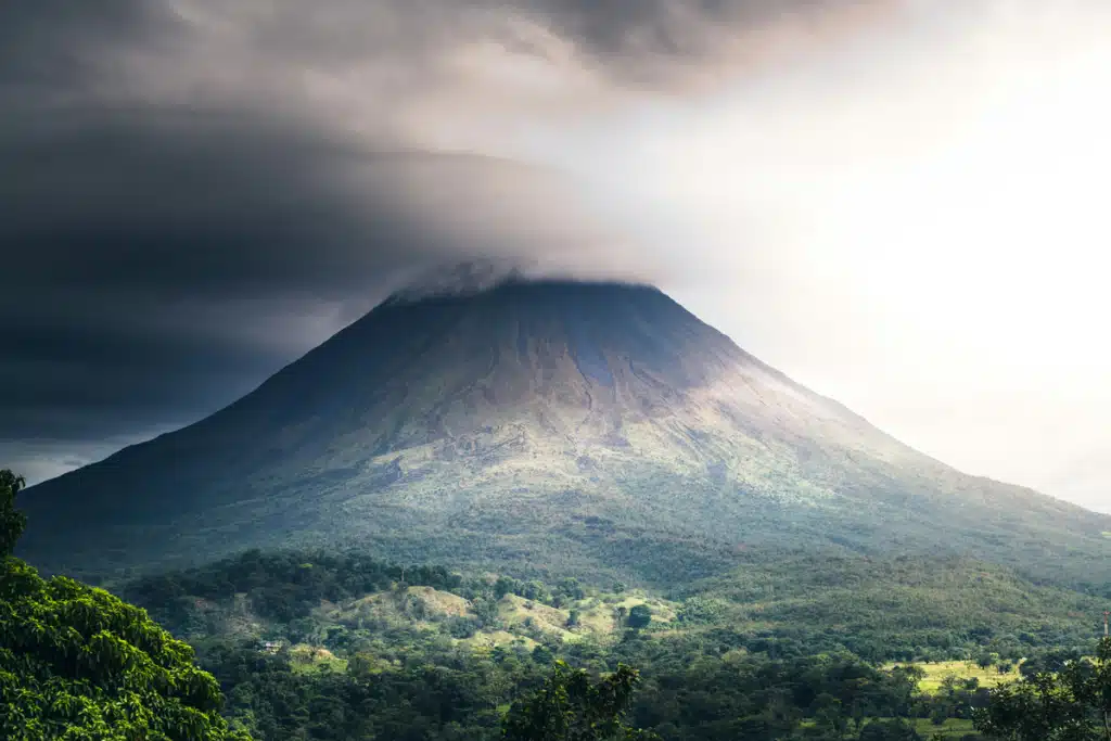 A volcano reaching up into clouds, somewhere in Costa Rica, where Amazon does not deliver.