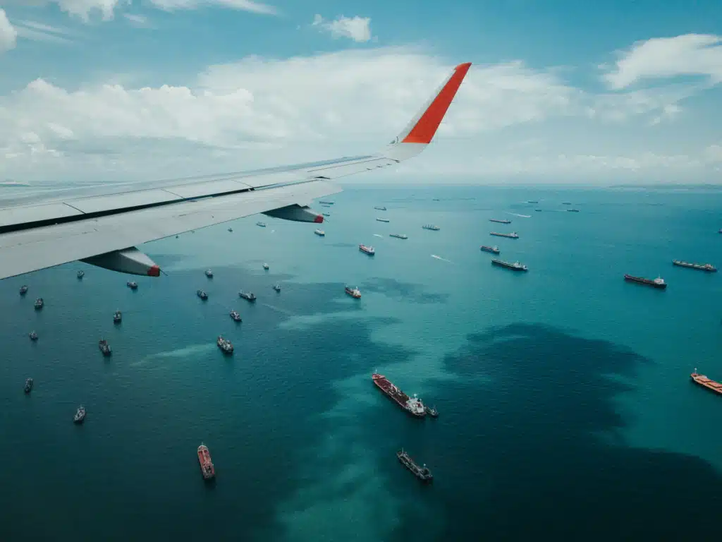 Shipping companies to Hawaii use both Air and Sea methods of transportation, like this photo taken from an airplane that shows the freight ships below.