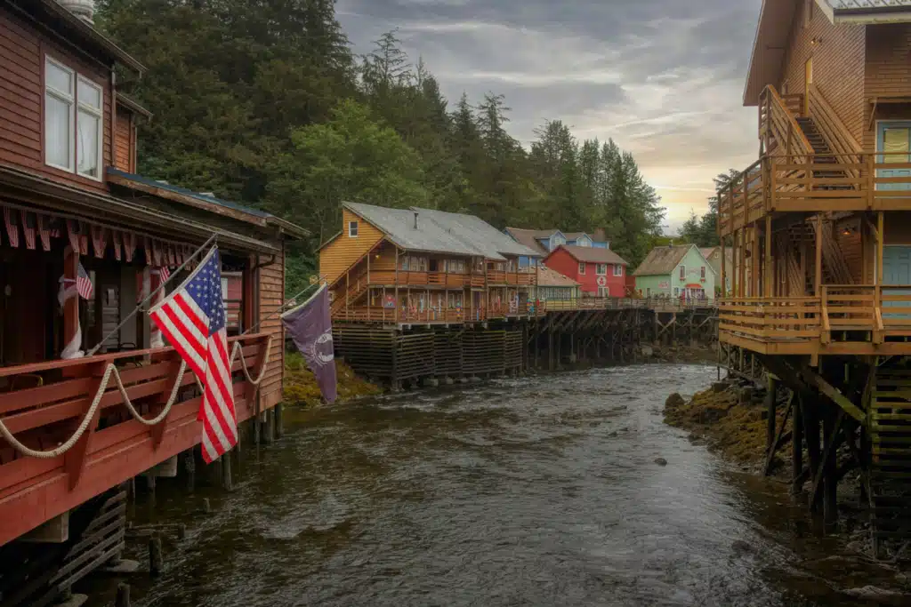 An American flag flies from a house in Alaska, along a river where salmon run.