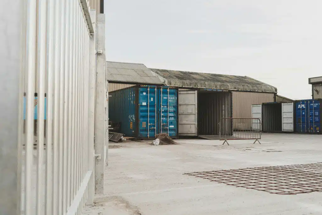 A loading dock on a sunny day. One truck is in the dock, unloading shipping for small business.