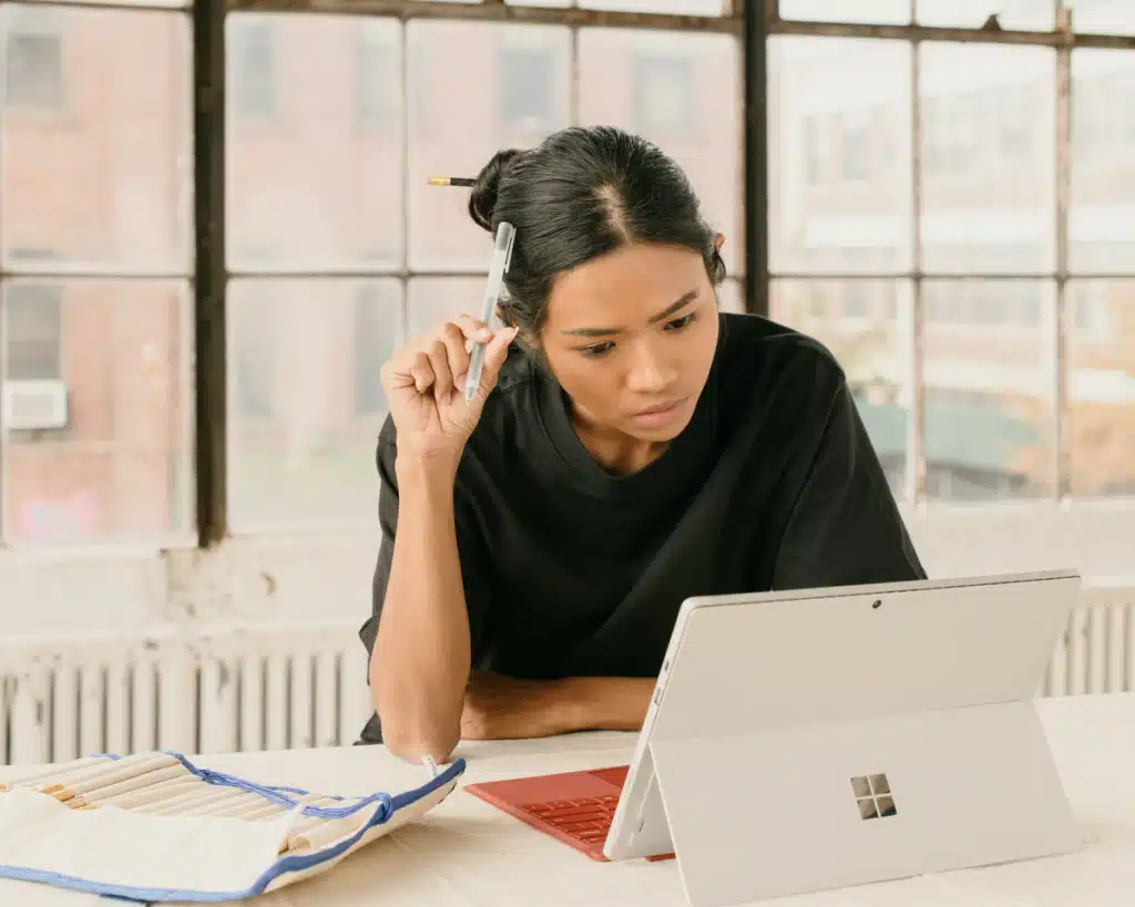 A small business owner and artist is looking on her Surface laptop how to get the best international shipping for small business.