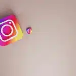 Graphics depicting Instagram buttons as 3D squares. A large one and a small one are on a light pink background.