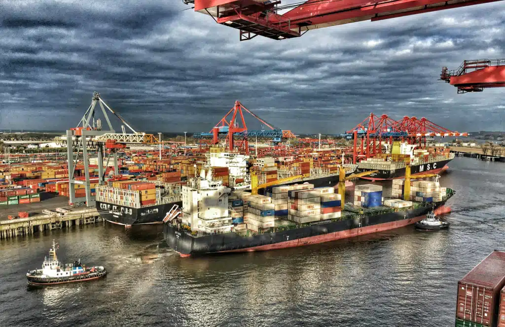 A cargo ship at a dock in the process of importing ecommerce international shipping goods.