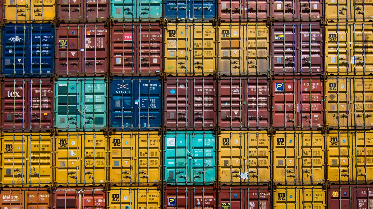 Shipping crates of various colours are stacked on top of each other. Many of them are filled for the purpose of shipping boxes overseas.