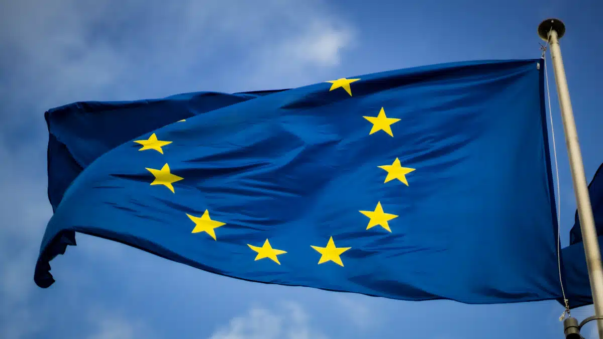 The EU flag flying in a blue sky.