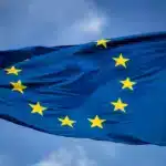 The EU flag flying in a blue sky.