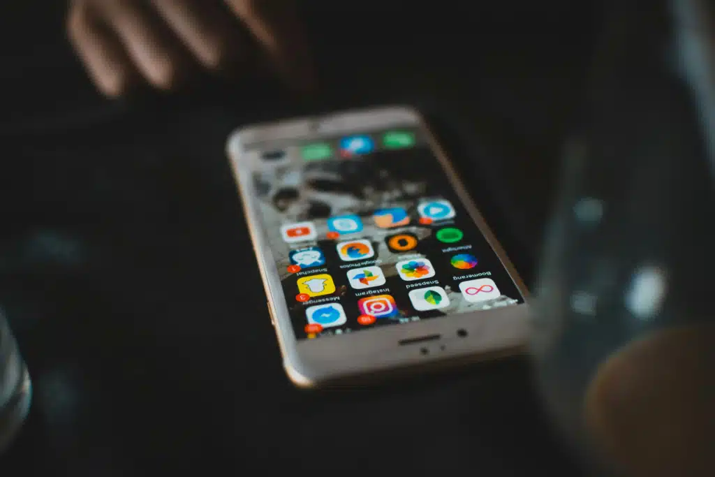 Someone is looking at the home screen of their iPhone, where the Instagram app is installed so they can learn how to add shop button on Instagram.