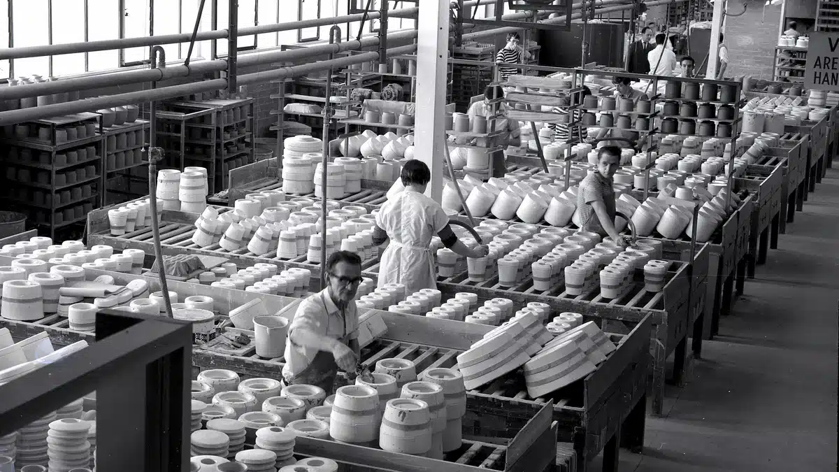 A vintage black and white photo of some potters doing order fulfillment from a factory.