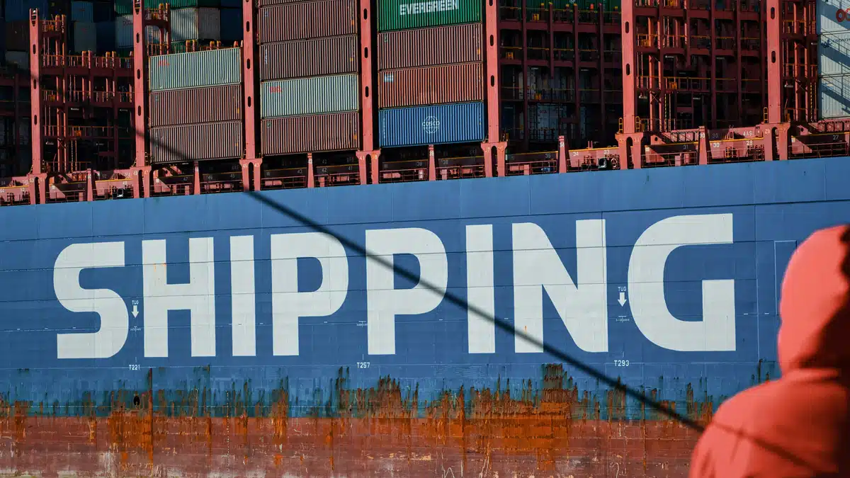 A cargo ship used for ecommerce international shipping. It is blue with white text that says "shipping" on the side.