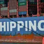 A cargo ship used for ecommerce international shipping. It is blue with white text that says "shipping" on the side.