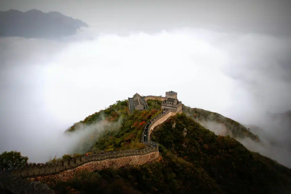 The great wall of China on a hill during a foggy day.