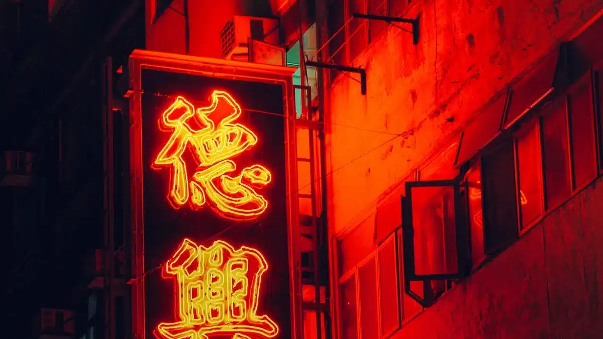 A red sign is lit up at night on a store front in Hong Kong, where shipping from the US is easy with PostFromUS.