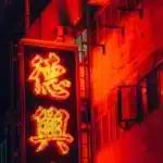 A red sign is lit up at night on a store front in Hong Kong, where shipping from the US is easy with PostFromUS.