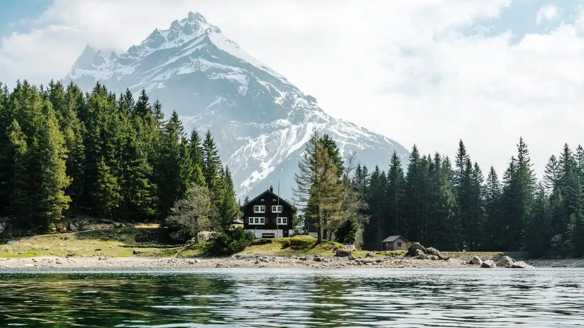 A water-font cabin in Switzerland has trees and mountains around it. Shipping to Switzerland from US is easy with PostFromUS, even remote cabins like this one!