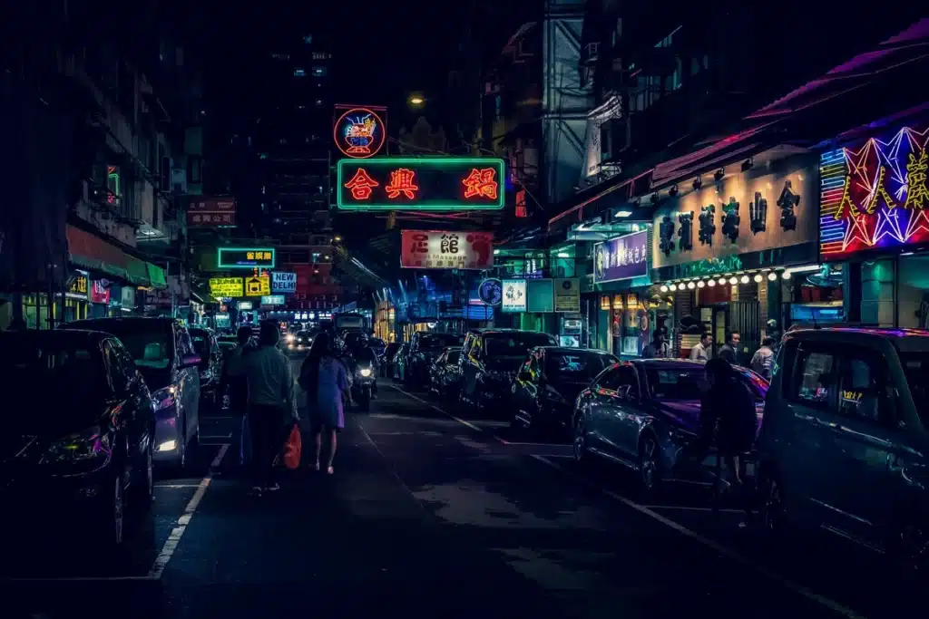 Hong Kong at night, which is lit up and bustling.