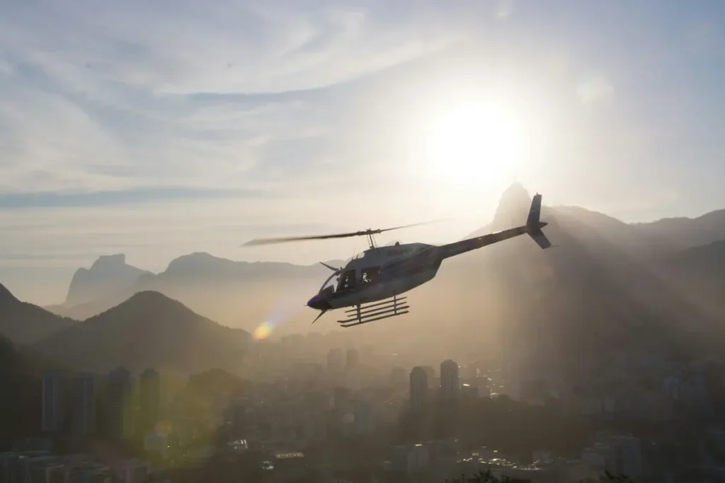 A helicopter is aiding in shipping from US to Brazil, flying over hills.