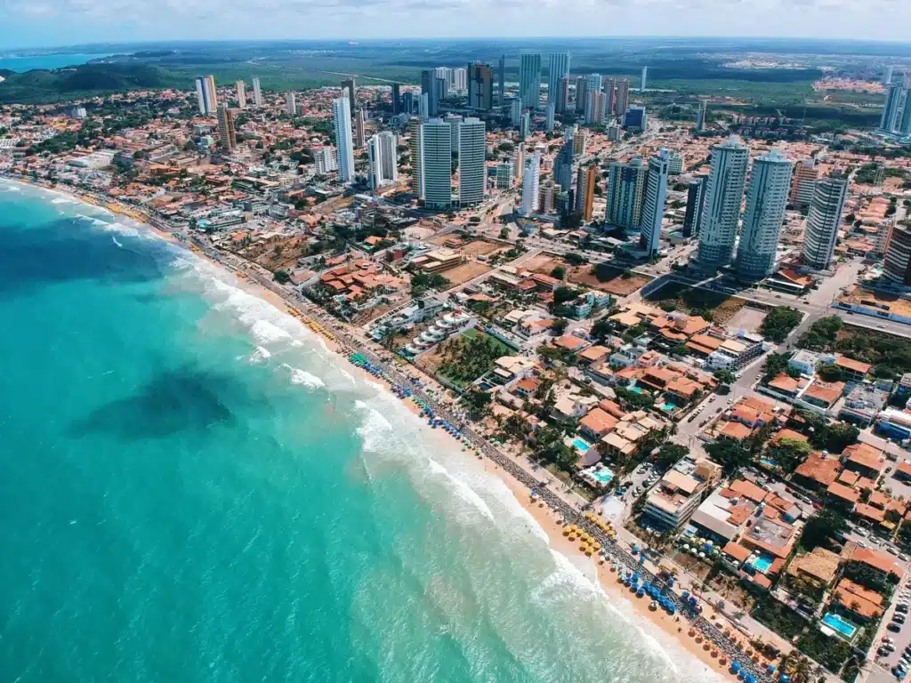 An aerial shot of a sunny, coastal city in Brazil where shipping from US comes in through sea and air freight. 