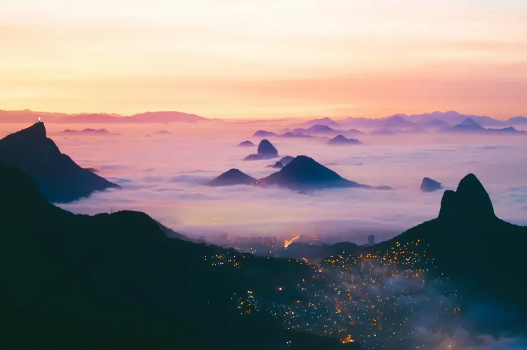 Cloudy mountain tops under an orange sunset in Brazil.